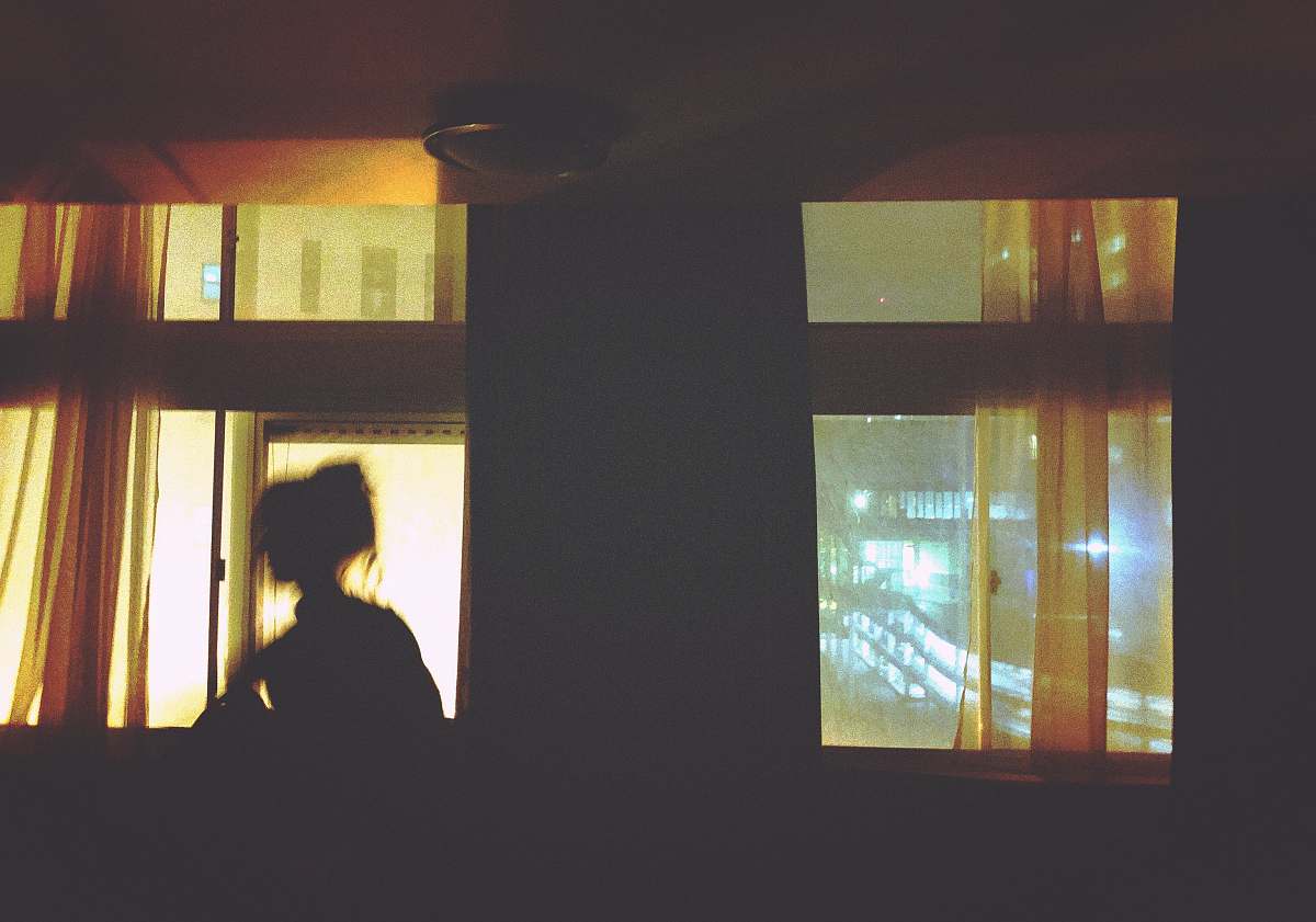 light fixture silhouette of woman standing in front of window poster